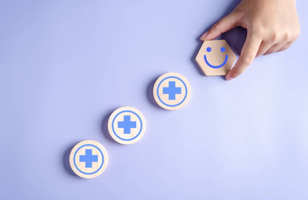 hands holding happy smile face. mental health positive thinking and growth mindset with plus sign concept.